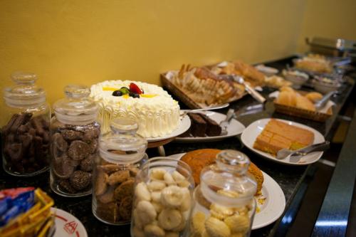 a table topped with a cake and jars of food at Atalaia Palace Hotel in Guarapuava