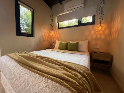 Un dormitorio con una cama blanca y dos ventanas. en Depto Estudio Mar 2 personas, en Miramar