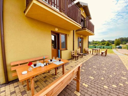 a patio with benches and tables and a balcony at Ptasi Raj in Karwia