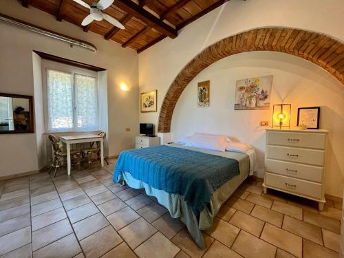 a bedroom with a bed and a table in a room at B&B La Fucinaia Pet Friendly Adults only in Campiglia Marittima