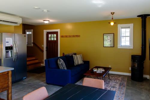Una sala de estar con un sofá azul y una mesa. en Dwntwn home, Prvt Rooftop and Soaking Tub!, en Burlington