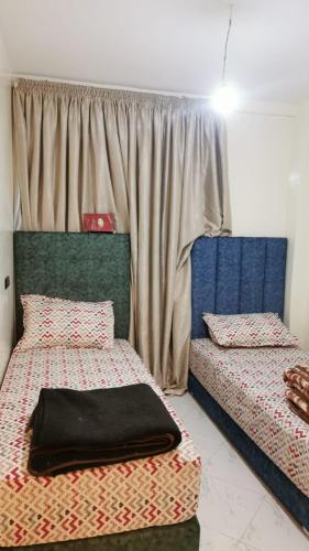 a bedroom with two beds and a window at Appartement Proche plage Bouznika Bouznika in Bouznika