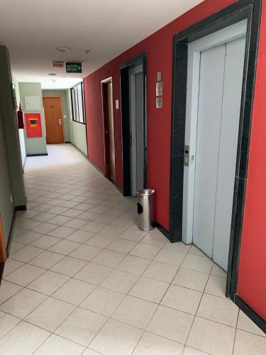 an empty hallway of an office building with red walls at Flat no Condomínio Metrópolis - Ilha do Leite in Recife