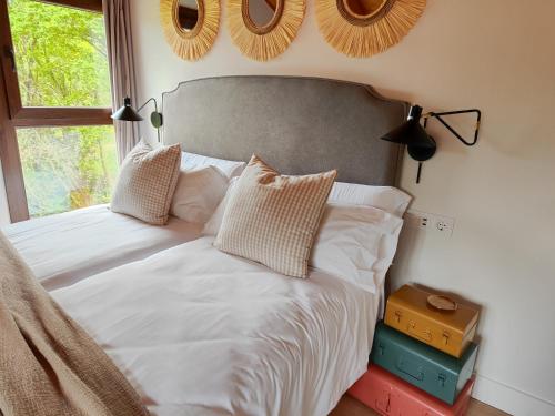 a bed with white sheets and pillows in a bedroom at Reguero Gato Turismo Rural in Candamo