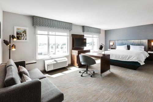 a hotel room with a bed and a desk at Hampton Inn & Suites by Hilton Québec - Beauport in Quebec City