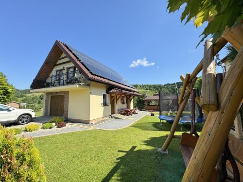 a house with a green yard with a swing at Agroturystyka Wilkowyja in Mchawa