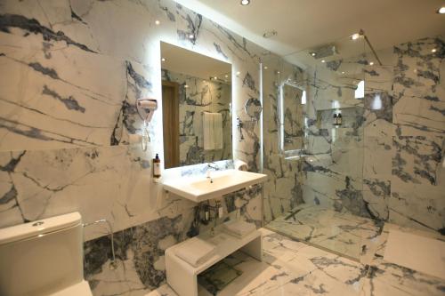 a marble bathroom with a sink and a toilet at 555 Hotel Clubbing Adults Only in Marrakech