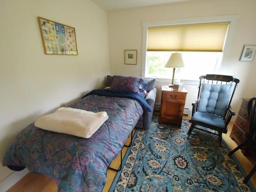 una camera con 2 letti singoli e una sedia di Spacious country retreat close to town and nature, Sylvana Farm VT a Montpelier