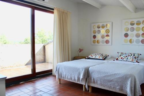 une chambre avec un lit et une grande fenêtre dans l'établissement Villa Marguerite, à Lorgues