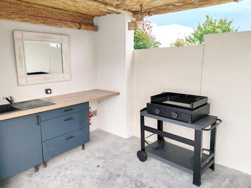 une cuisine avec un grill, un comptoir et un évier dans l'établissement Villa de la Raho, à Villeneuve-de-la-Raho