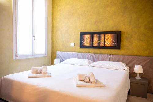 a bedroom with a white bed with towels on it at Al Podestà - Centro Storico in Mantova