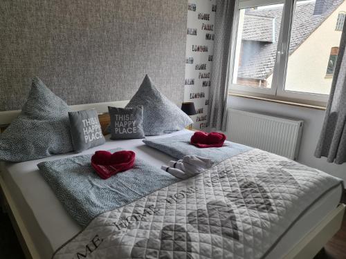 a bed with two red hearts and pillows on it at Schöne 3 Zimmer Wohnung in Oberwesel