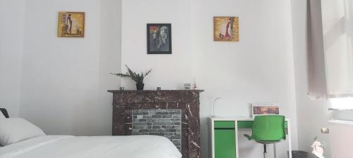 a bedroom with a bed and a brick fireplace at Chambre R0 avec salle de bain partagée près de l'hôpital de la Citadelle à Liège in Liège