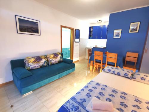 a living room with a blue couch and a table at Durakovic Apartments in Herceg-Novi