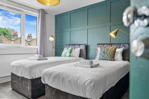 two beds sitting next to each other in a bedroom at Spacious 3 bedroom Whitechapel Apartment with Garden by Gold Stays in London