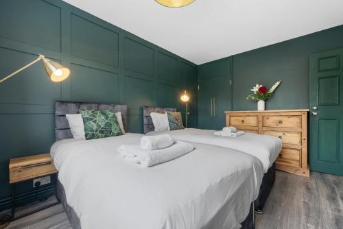a bedroom with a large bed with towels on it at Spacious 3 bedroom Whitechapel Apartment with Garden by Gold Stays in London