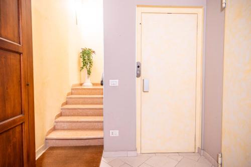 a hallway with a door and stairs with a plant at Al Podestà - Centro Storico in Mantova