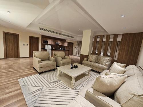 a living room with couches and a coffee table at Dream Residence Olaya Khobar in Al Khobar