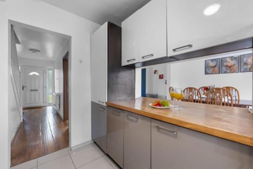 a kitchen with white cabinets and a wooden counter top at Legacy House - Secured Parking on Site in Tollbar End