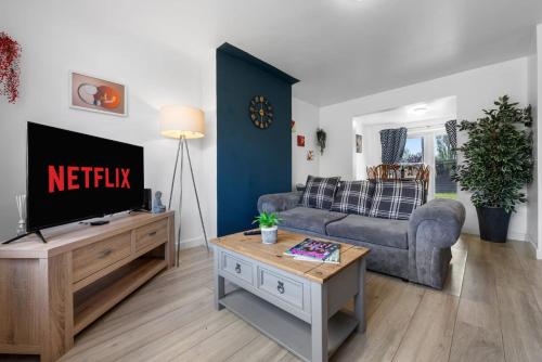 a living room with a couch and a tv at Legacy House - Secured Parking on Site in Tollbar End