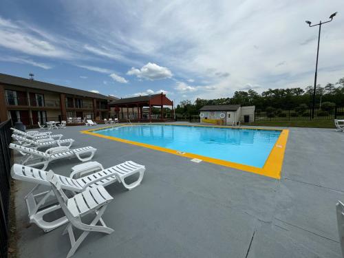 a swimming pool with lounge chairs and a hotel at Quality Inn Mason Near Kings Island in Mason