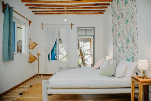 a bedroom with a white bed and a window at Ocean Boho House in Jambiani