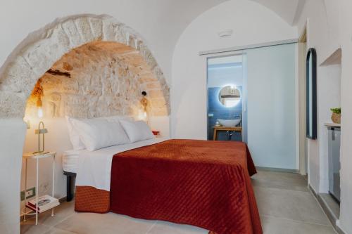 a bedroom with a bed and a stone wall at Dimora Lavinia Casa vacanze Centro storico Ostuni in Ostuni