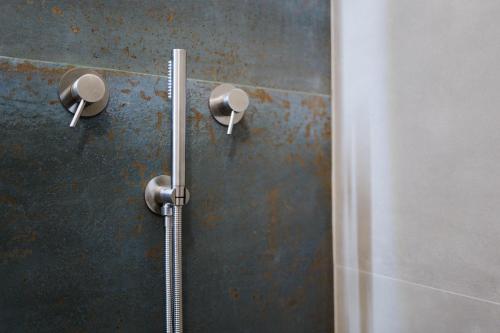 a shower with two shower heads on a wall at Dimora Lavinia Casa vacanze Centro storico Ostuni in Ostuni