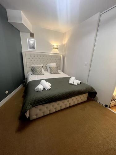 une chambre avec un lit avec des serviettes dessus dans l'établissement WonderSuite appartement - centre ville avec parking couvert -15mn de Paris et 10 mn de Stade de France, wifi, Netflix, à Deuil-la-Barre