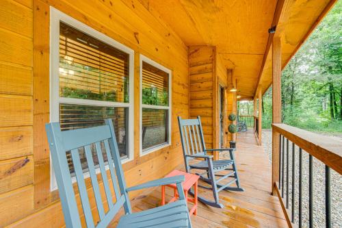 two blue chairs sitting on the porch of a cabin at Broken Bow Cabin with Private Hot Tub 14 Mi to Lake in Broken Bow