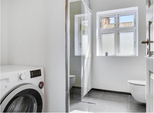 a white bathroom with a washing machine in it at Ingemannsvej 13, Fredericia in Fredericia