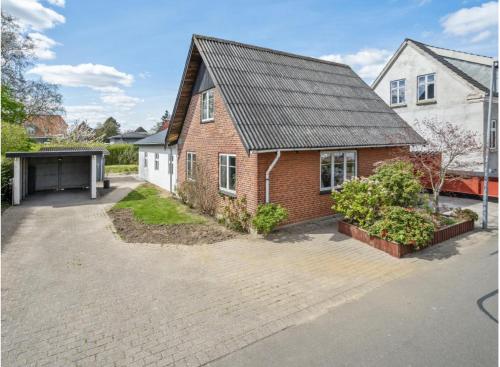 a brick house with a black roof and a driveway at Ingemannsvej 13, Fredericia in Fredericia
