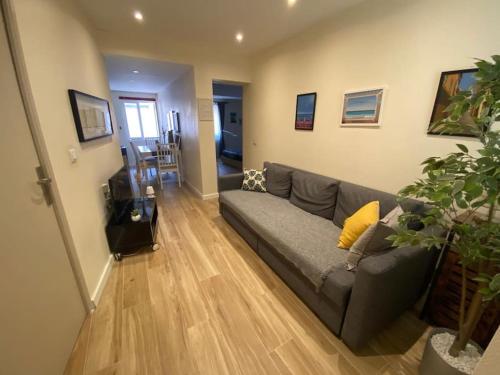 - un salon avec un canapé gris et du parquet dans l'établissement 2 pièces Vieux Nice - Deux pas de la mer, à Nice