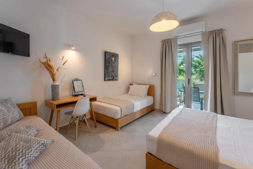 a bedroom with two beds and a desk with a computer at Yiasemi in Skiros