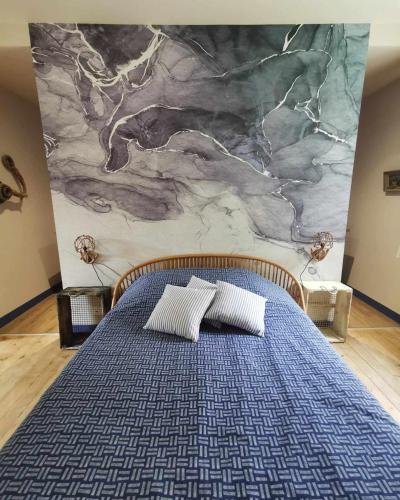a bed with two pillows in front of a marble wall at Bulle marine paisible proche de la gare et du port in Brest