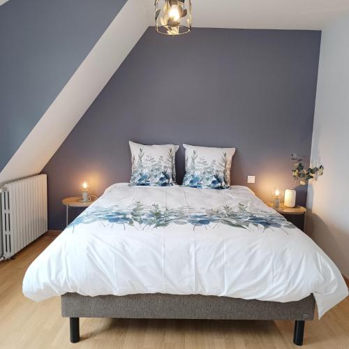 une chambre avec un grand lit aux murs bleus dans l'établissement La maison d'à côté, à Montreuil-sur-Mer