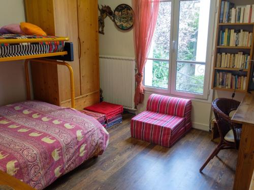 une chambre avec un lit, une chaise et une fenêtre dans l'établissement Maison avec jardin à deux pas de Paris, à Vanves