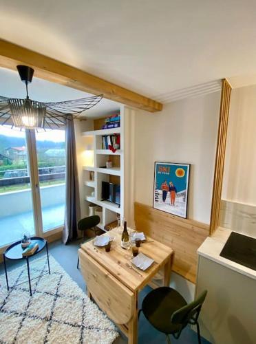 un salon avec une table et des chaises et une fenêtre dans l'établissement Appartement 4 personnes centre village, à Samoëns