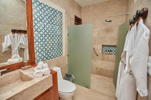 a bathroom with a sink and a toilet and a shower at Villas Caracol in Holbox Island