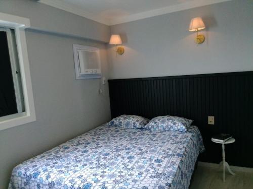 um quarto com uma cama e duas almofadas em Via expressa l queen l ar cond l tv smart l wi-fi l cozinha completa em Maceió
