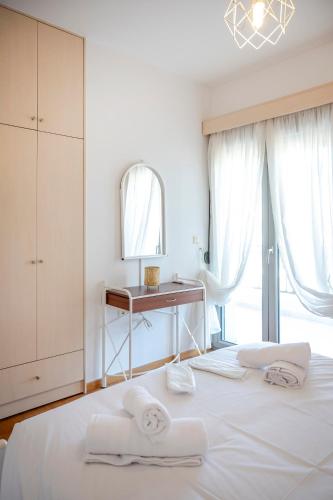 a white bedroom with a bed with towels on it at City Calm House in Platánion