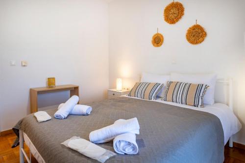 a bedroom with a large bed with towels on it at City Calm House in Platánion