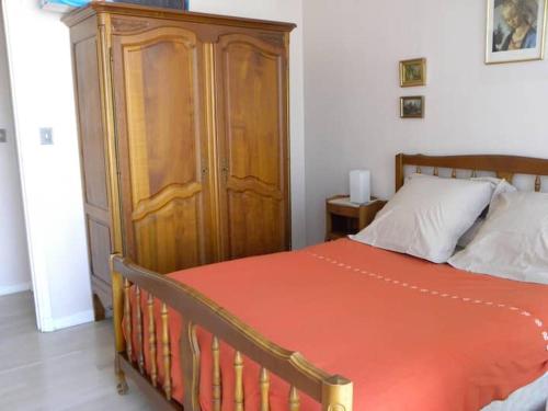 une chambre avec un lit et une armoire en bois dans l'établissement T2, centre village, belle terrasse proche plages, à Cassis