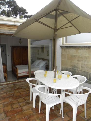- une table et des chaises blanches avec un parasol sur la terrasse dans l'établissement T2, centre village, belle terrasse proche plages, à Cassis