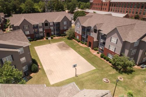 an overhead view of an apartment complex with a basketball court at Vibrant Living Near Auburn University l 4BR 4BA in Auburn