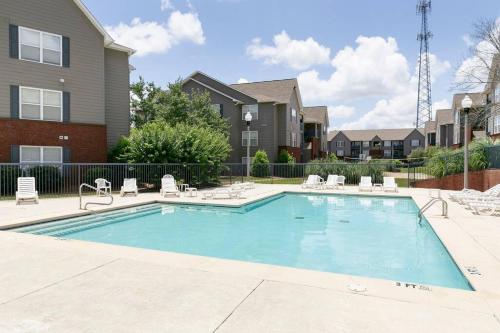 a swimming pool with chairs and a house at Vibrant Living Near Auburn University l 4BR 4BA in Auburn