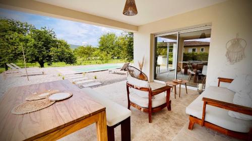 une salle à manger avec une table et des chaises et une piscine dans l'établissement Villa Lou Pénéquet Salernes, à Salernes