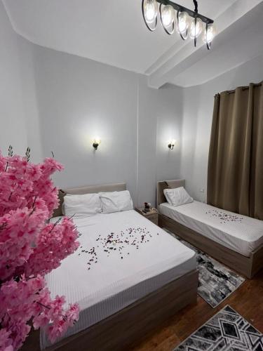 two beds in a room with pink flowers on the bed at Downtown view studios in Cairo