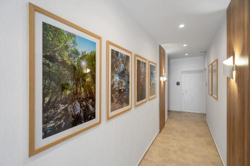 a hallway with a bunch of paintings on the walls at Faflagos Apartments in Psari Forada