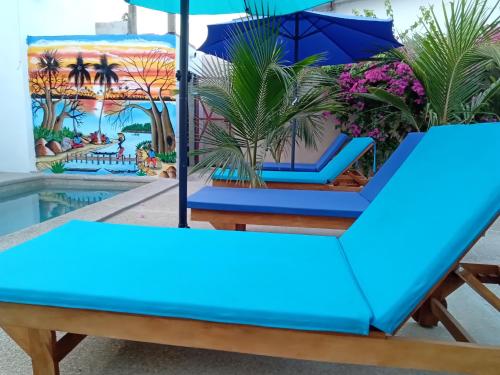 a blue table and chairs next to a pool at Le GANGA LODGE in Ndangane